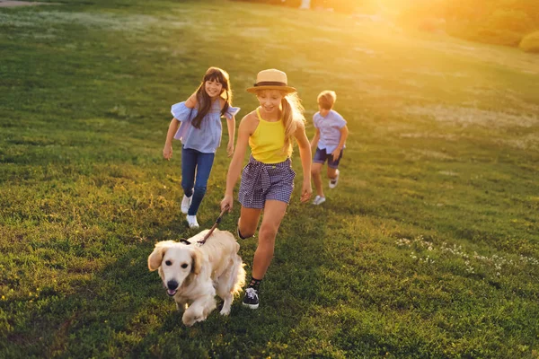 Teenagers walking with dog — Stock Photo