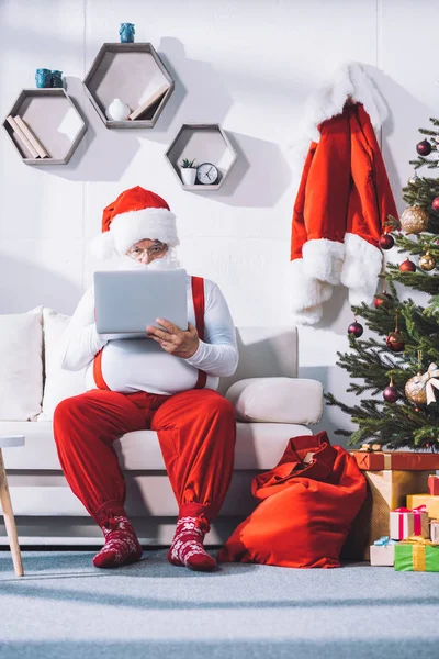 Père Noël en utilisant un ordinateur portable — Photo de stock