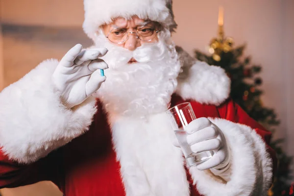 Weihnachtsmann mit Medikamenten in der Hand — Stockfoto