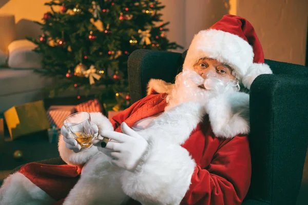 Santa Claus con vaso de whisky y cigarro - foto de stock