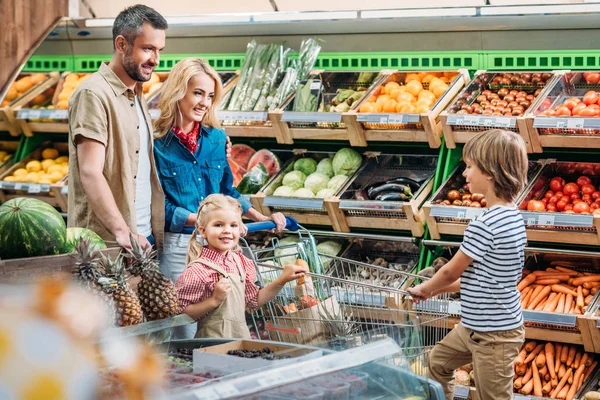 Famille avec panier au supermarché — Photo de stock