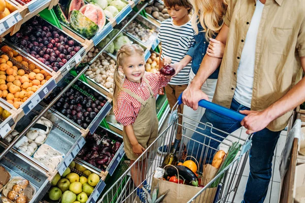 Family with shopping trolley in supermarket — Stock Photo