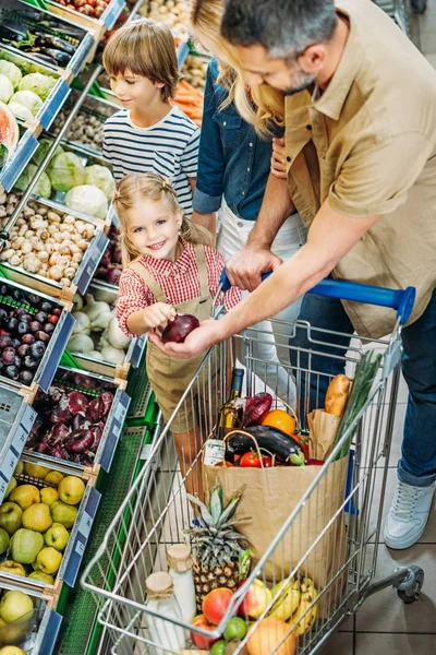 Family with shopping trolley in supermarket — Stock Photo