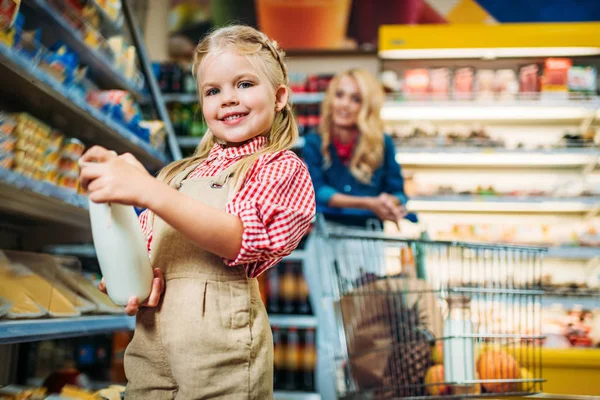 Niña sosteniendo botella de leche - foto de stock