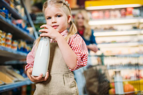 Niña sosteniendo botella de leche - foto de stock