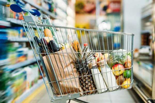 Shopping cart with purchases in supermarket — Stock Photo