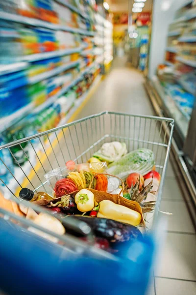 Carrito de compras con compras en el supermercado - foto de stock