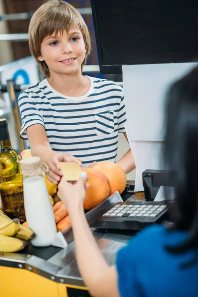 Niño haciendo el pago en el supermercado - foto de stock