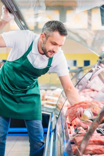 Negozio assistente assortimento carne cruda — Foto stock