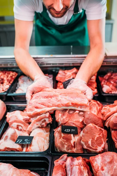 Assistente de loja com carne crua — Fotografia de Stock