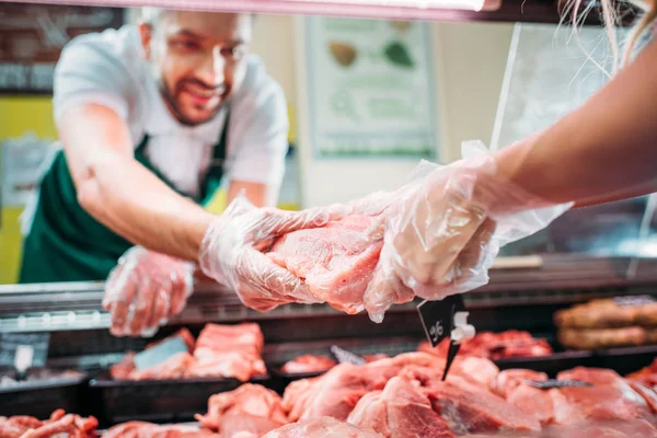 Asistentes de tienda con carne cruda - foto de stock