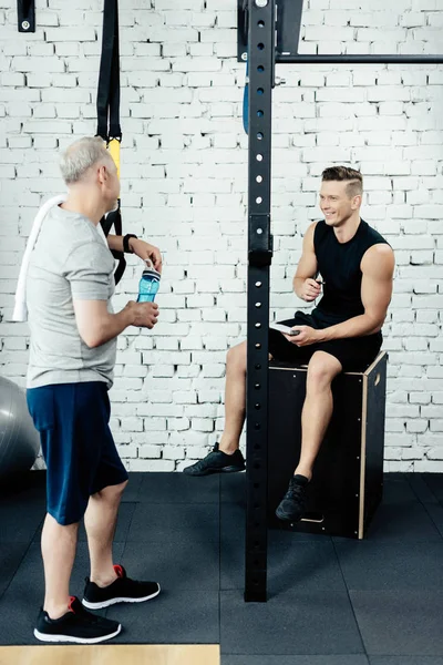 Trainer talking with senior sportsman — Stock Photo