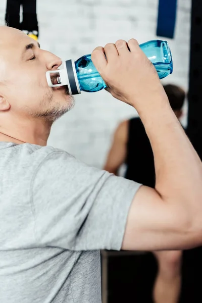 Senior sportsman drinking water — Stock Photo