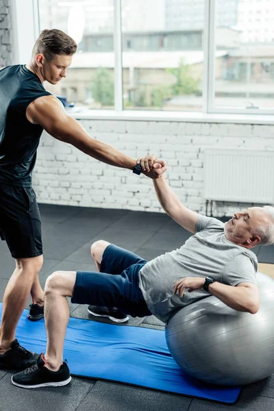 Desportista sênior na bola de fitness — Fotografia de Stock