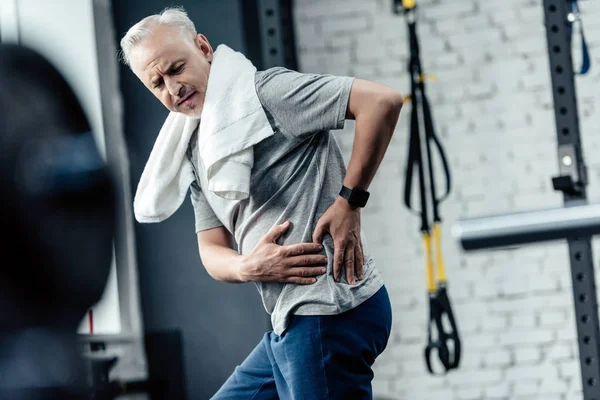 Deportista senior con dolor de espalda - foto de stock