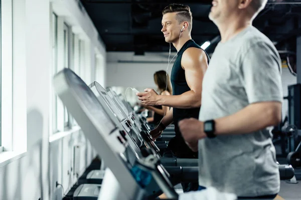 Sportsmen training on treadmills — Stock Photo