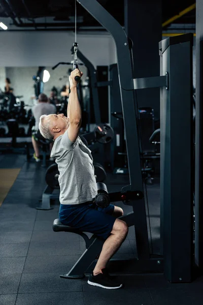 Senior Sportler beim Heben von Gewichten — Stockfoto