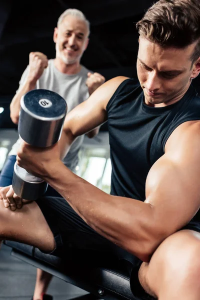 Sportsman training with dumbbell — Stock Photo