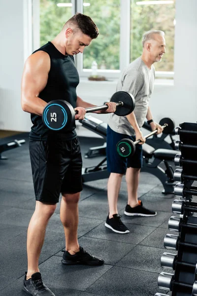 Sportsmen training with barbells — Stock Photo