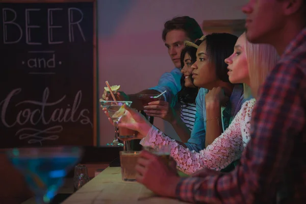 Amigos multiétnicos beber cócteles en el bar - foto de stock