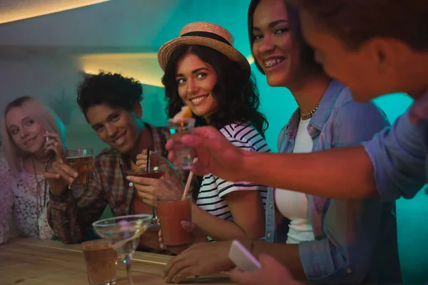 Amici multietnici bere cocktail nel bar — Foto stock
