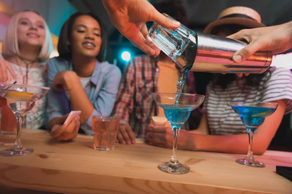 Barman making cocktail for friends — Stock Photo