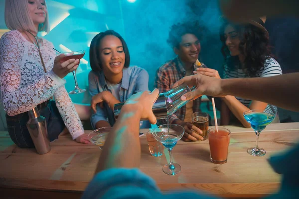 Barman making cocktail for friends — Stock Photo