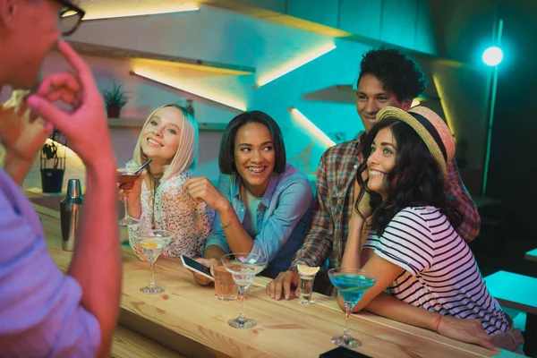 Multicultural friends with drinks in bar — Stock Photo