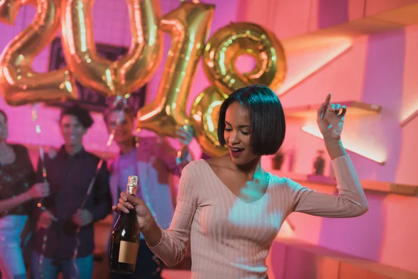 African american woman with bottle of champagne — Stock Photo