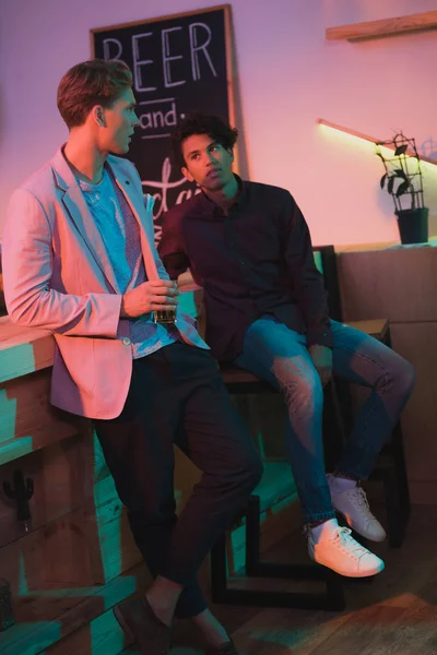 Multiethnic men having conversation in bar — Stock Photo