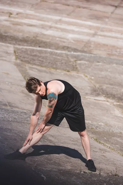 Man stretching on slabs — Stock Photo