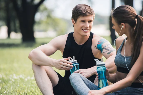 Sportive couple resting in park — Stock Photo