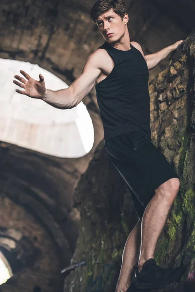 Homme sportif grimpant sur les ruines — Photo de stock