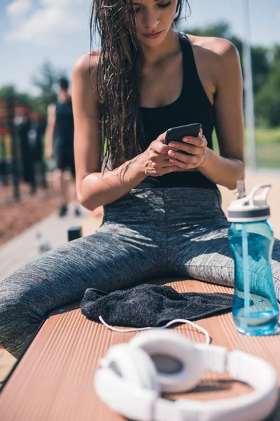 Спортивна жінка використовує смартфон — стокове фото