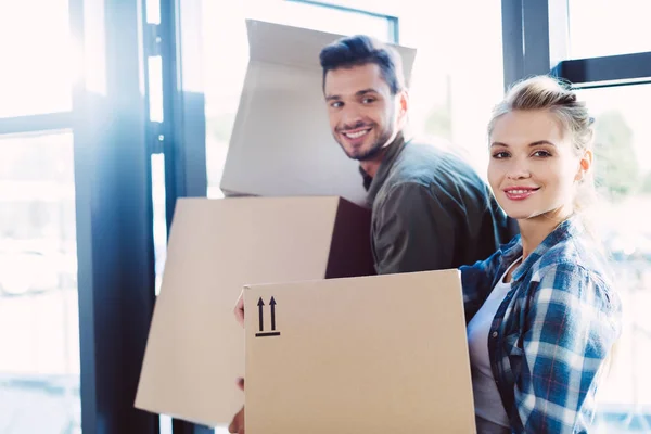 Couple with cardboard boxes in new house — Stock Photo