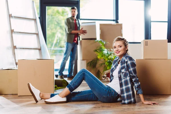 Couple with cardboard boxes in new house — Stock Photo