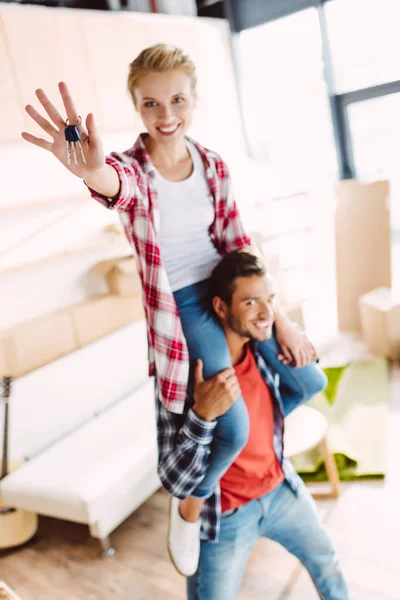 Couple with keys in new house — Stock Photo