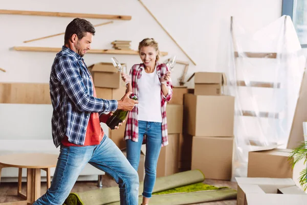 Pareja bebiendo champán en nueva casa - foto de stock