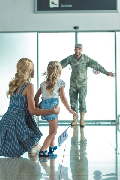 Feliz niño corriendo a padre en uniforme militar - foto de stock