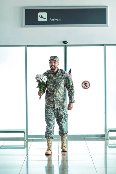 Soldier with bouquet of flowers — Stock Photo