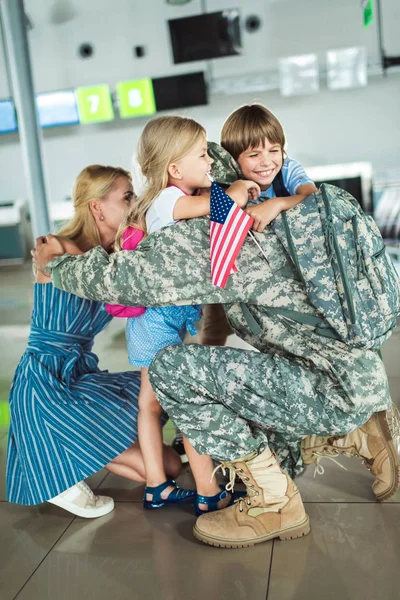 Семья обнимает отца в аэропорту — стоковое фото