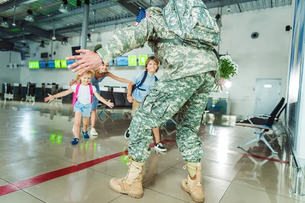 Familia encuentro padre en uniforme militar - foto de stock