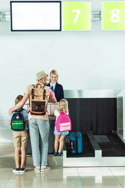 Familia en el mostrador de facturación en el aeropuerto - foto de stock
