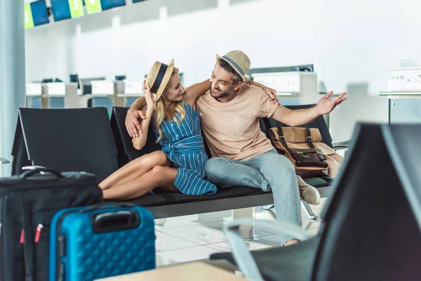 Pareja esperando el embarque en el aeropuerto - foto de stock