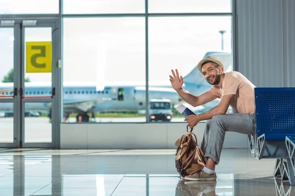 Man waving to someone in airport — Stock Photo
