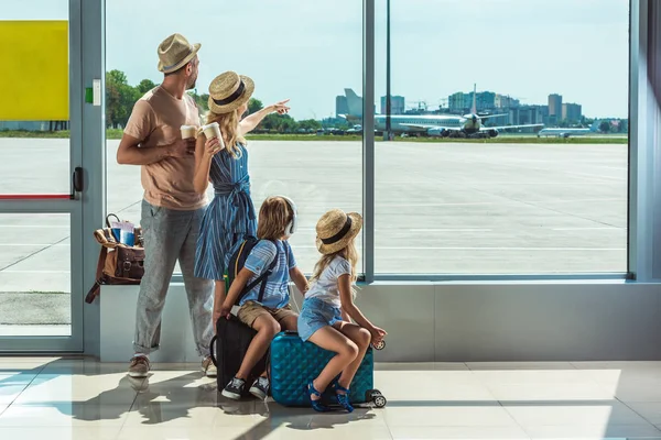 Family looking out window in airport — Stock Photo