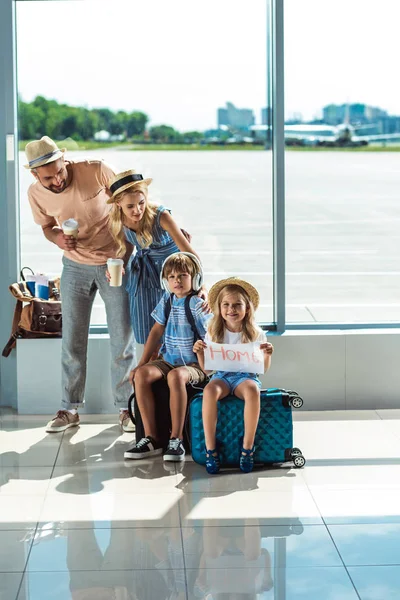 Padres e hijos esperando el embarque en el aeropuerto - foto de stock