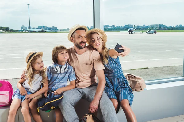 Happy family taking selfie in airport — Stock Photo