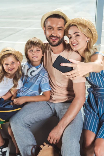 Happy family taking selfie in airport — Stock Photo