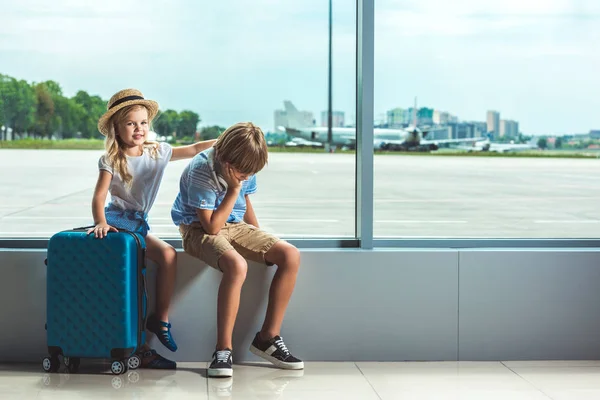 Hermanos esperando en el aeropuerto - foto de stock